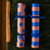 4143knallbonbonsblauepunkte Avayves Feine Papeterie Und Geschenke Für Babys Und Kids Eight peach and blue patterned party crackers tied with blue ribbons, arranged in two columns.