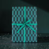 teal and dark-teal checkered gift box wrapped with a teal ribbon bow on a dark surface