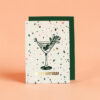 2380grusskarteb6happybirthdayhell Avayves Feine Papeterie Und Geschenke Für Babys Und Kids Birthday card featuring a martini glass drawing, confetti pattern, and gold 'Happy Birthday' text on a peach background with a green envelope behind it.