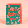 Bright teal birthday card with bold red 'HAPPY BIRTHDAY' text and abstract shapes, set against a pink background.