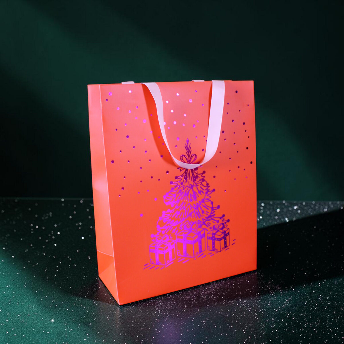 4185geschenktaschelweihnachtsbaum Avayves Feine Papeterie Und Geschenke Für Babys Und Kids Orange gift bag with white handles and a purple speckled pattern, set against a dark, starry green background.