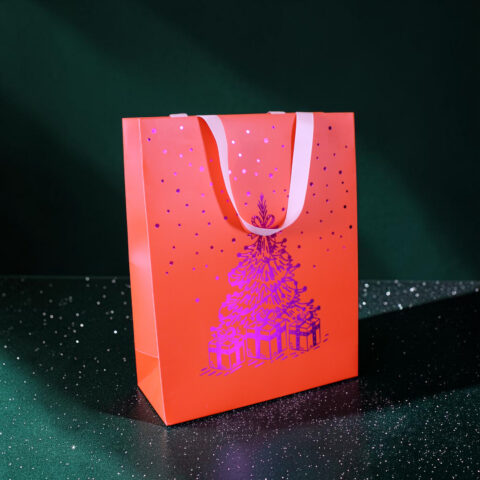 Orange gift bag with white handles and a purple speckled pattern, set against a dark, starry green background.