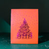 4185geschenktaschelweihnachtsbaum02 Avayves Feine Papeterie Und Geschenke Für Babys Und Kids Decorative orange panel with purple polka dots and a purple Christmas tree and gifts illustration on a dark background