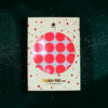 4188enveloperoundstickerneonrot Avayves Feine Papeterie Und Geschenke Für Babys Und Kids Packaging for Sticker-Set rund with a circular window showing bright pink polka-dotted stickers on white backing, scattered confetti on a green background.