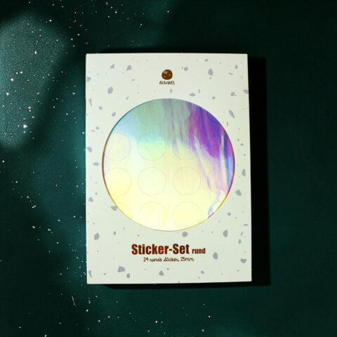 White box with gray speckles showing a large holographic circular sticker sheet inside; text reads 'Sticker-Set rund' and '24 runde Sticker, 25mm' beneath the circle.