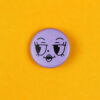 Purple circular button with a sleepy cartoon face on a bright yellow background.