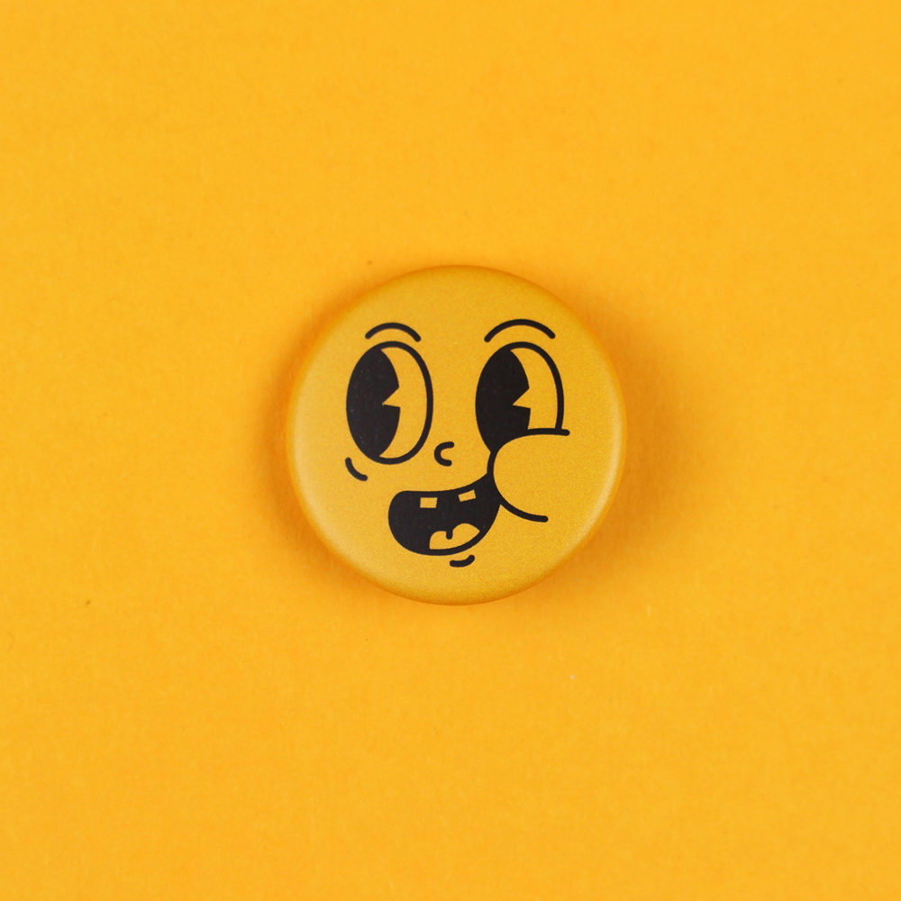 Close-up of a yellow round emoji button with a goofy, tongue-out facial expression on a yellow background.
