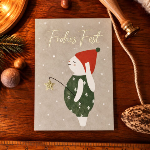 German Christmas card featuring a cute figure in a red hat and green outfit, holding a star wand; text reads 'Frohes Fest'