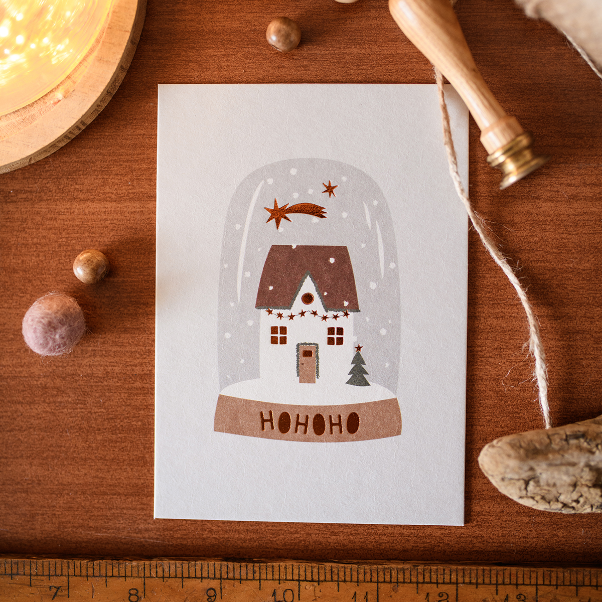 1276pkhohohoschneekugel Avayves Feine Papeterie Und Geschenke Für Babys Und Kids Holiday card featuring a snow-dome scene: a snow-covered house, small pine, and 'HOHOHO' at the base under a glass dome.