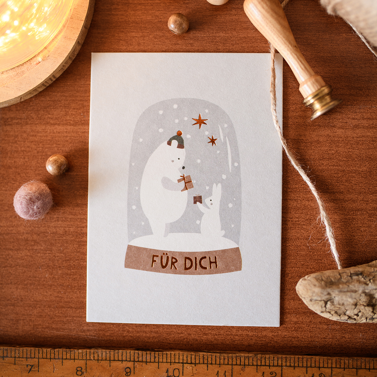 German Christmas card showing two white bears inside a snow globe with falling snow and stars, captioned 'FÜR DICH' on a brown ribbon.