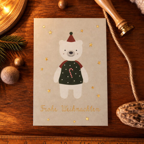 Christmas card with a smiling white bear in a green vest and red hat, candy cane on its chest, on a wooden desk with gold stars and 'Frohe Weihnachten'.