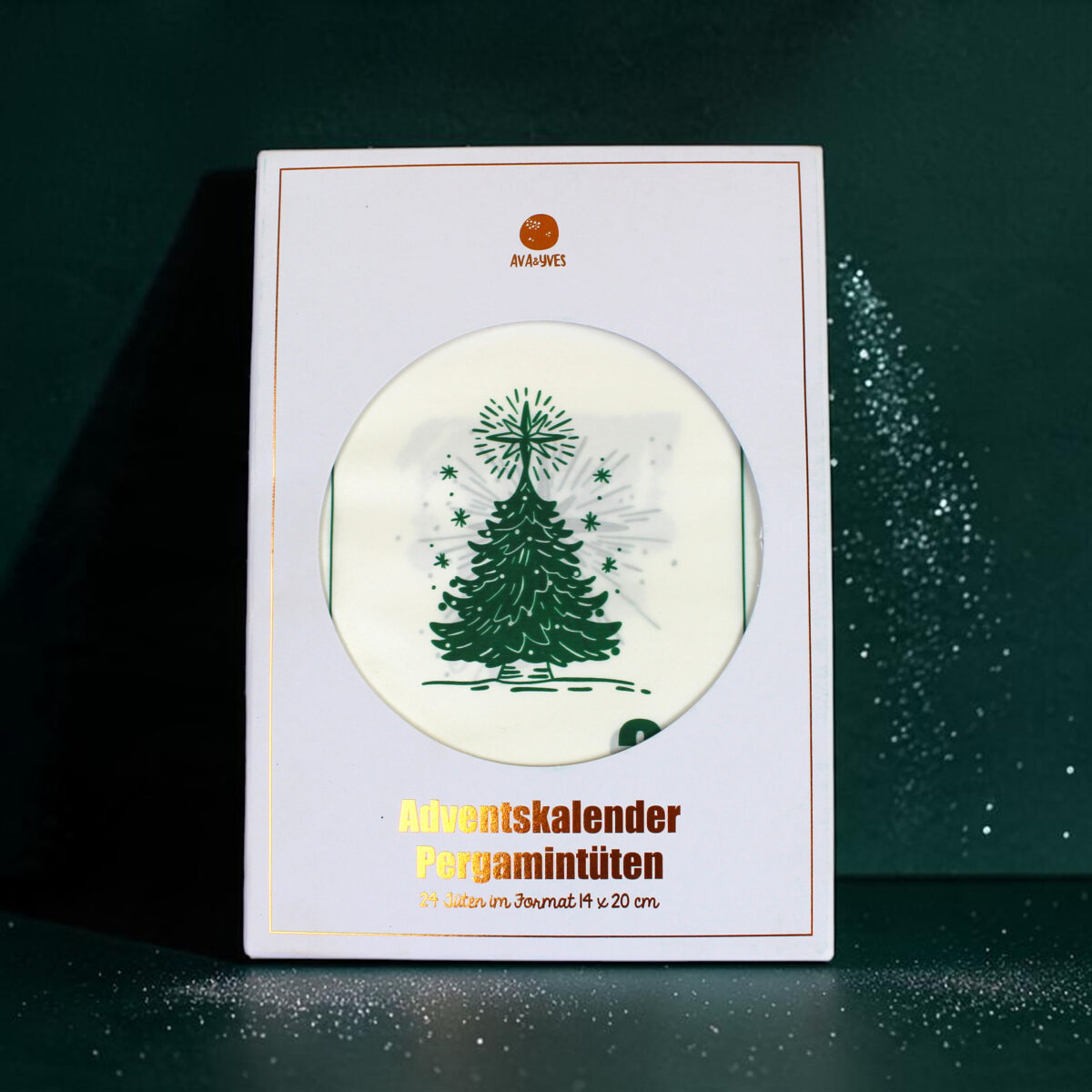 White Advent calendar box with a round window showing a green Christmas tree design and gold 'Adventskalender' text below, festive packaging edge visible.