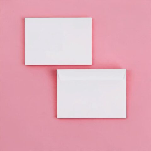 Two white envelopes on a pink background, one above the other.