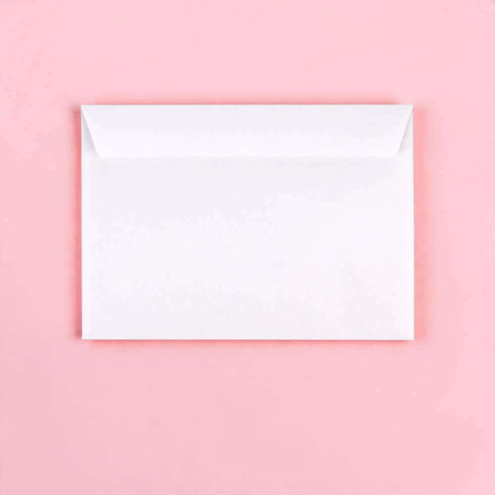 White envelope lying flat on a pastel pink background, closed and sealed.